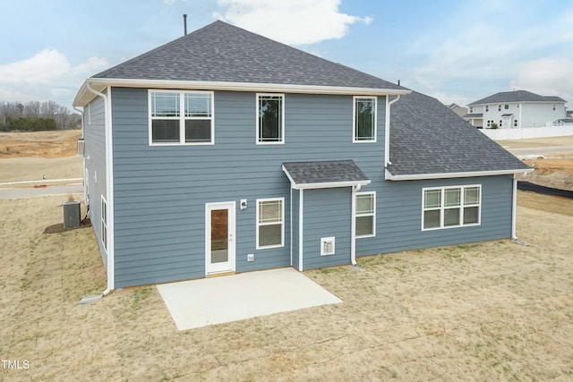 rear view of property with a yard, central AC, and a patio area