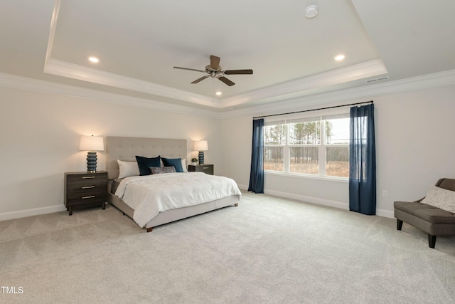 bedroom with crown molding, a tray ceiling, and light colored carpet