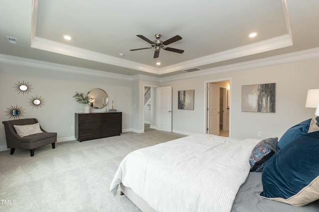 bedroom with crown molding, a tray ceiling, light colored carpet, and ceiling fan