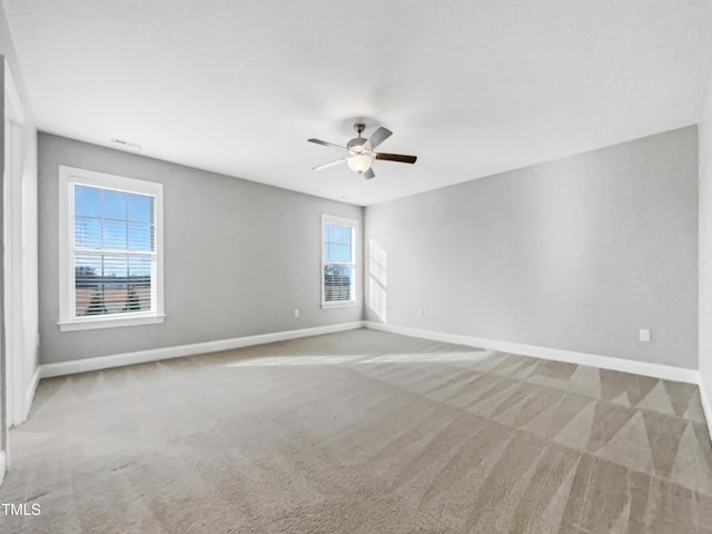 unfurnished room with ceiling fan and carpet