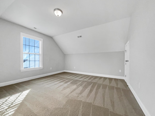 bonus room with carpet floors and vaulted ceiling