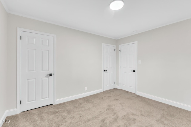 unfurnished room with ornamental molding and light colored carpet