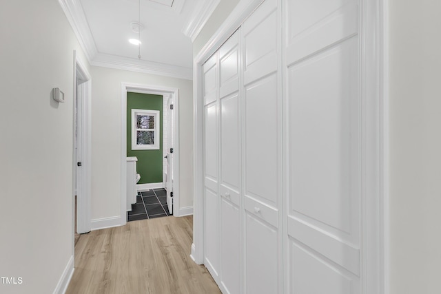 hallway with crown molding and light hardwood / wood-style flooring