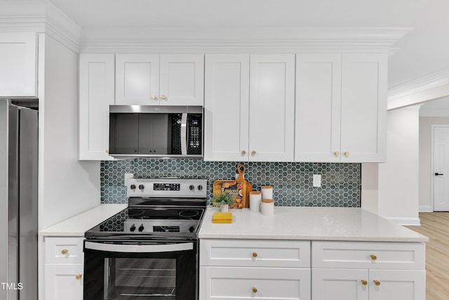 kitchen with appliances with stainless steel finishes, white cabinetry, backsplash, light stone counters, and crown molding