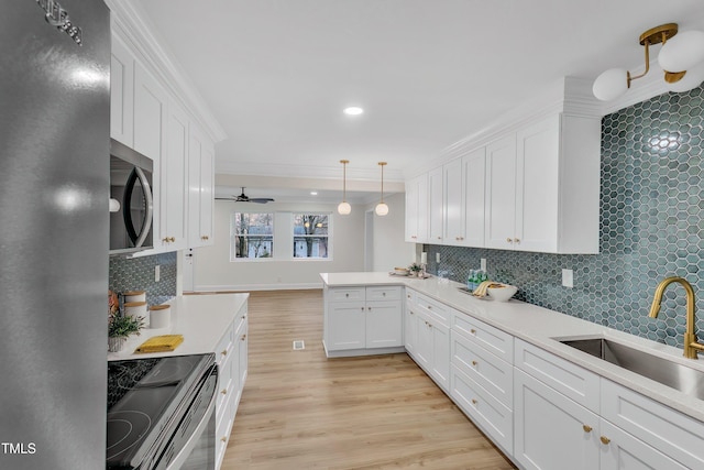 kitchen featuring sink, white cabinetry, appliances with stainless steel finishes, pendant lighting, and backsplash