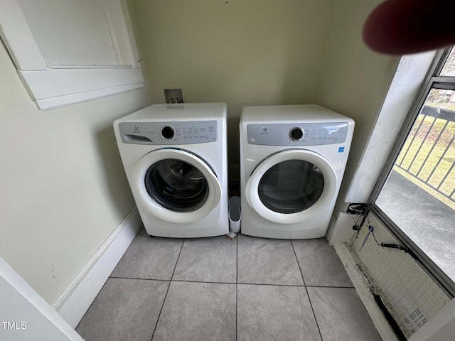 laundry room featuring washer and dryer and light tile patterned floors