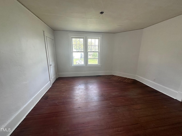 spare room with dark wood-type flooring