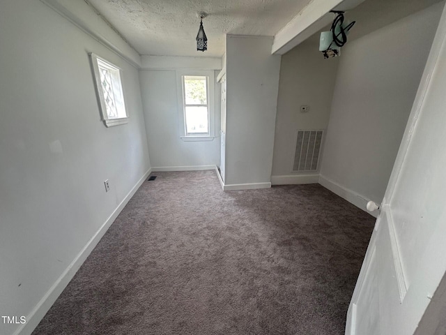 carpeted spare room featuring a textured ceiling