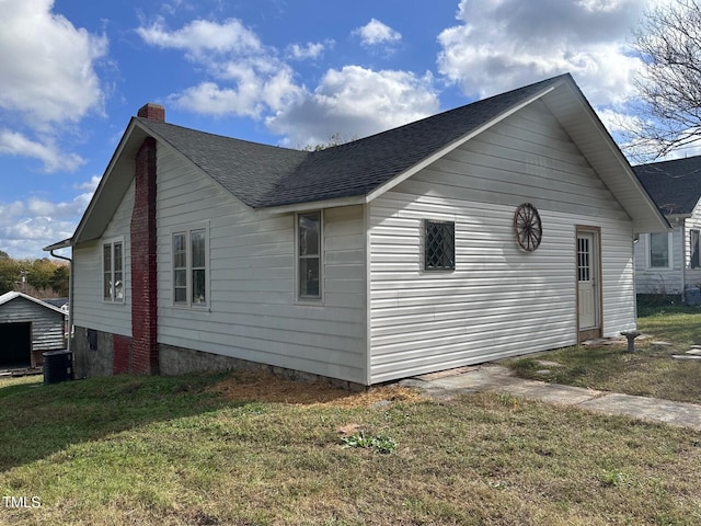 view of side of property with central AC and a lawn