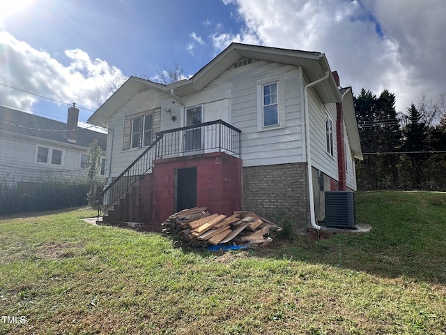 back of property with a yard and central air condition unit