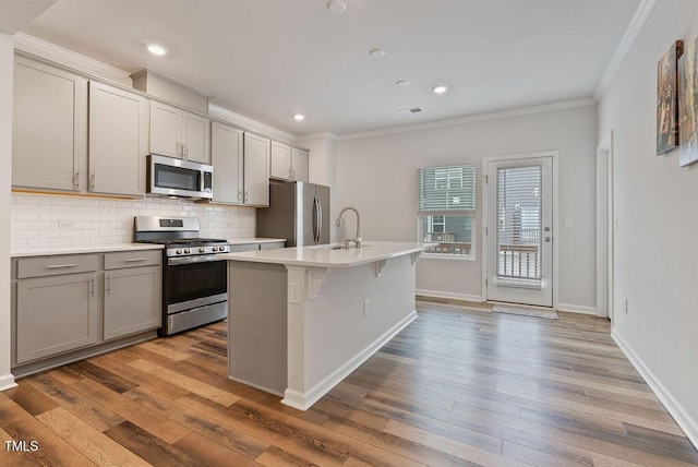 kitchen with a sink, light countertops, gray cabinetry, and appliances with stainless steel finishes