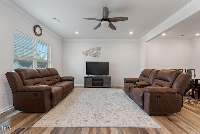 living room featuring light wood finished floors, ornamental molding, and visible vents