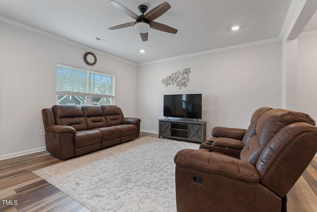 living area with baseboards, wood finished floors, and ornamental molding