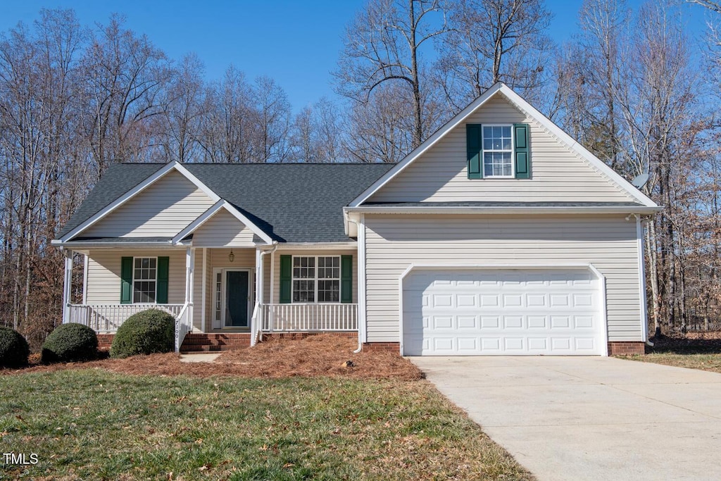 view of front facade with a garage, covered porch, and a front yard