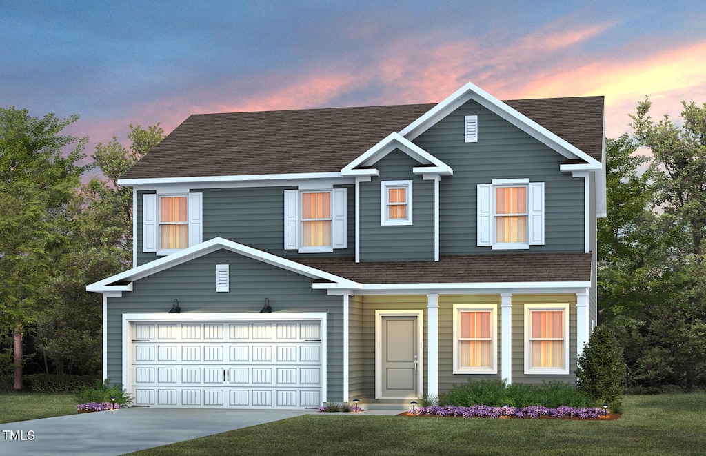 view of front of house featuring a garage and a lawn