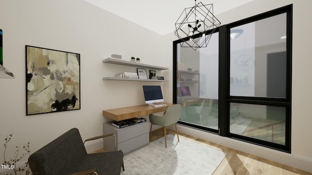 office area with an inviting chandelier, built in desk, and light wood-type flooring