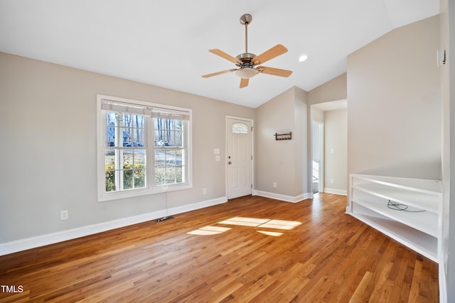 foyer entrance with hardwood / wood-style flooring, vaulted ceiling, and ceiling fan