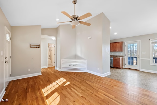 unfurnished living room with ceiling fan, lofted ceiling, and light hardwood / wood-style floors