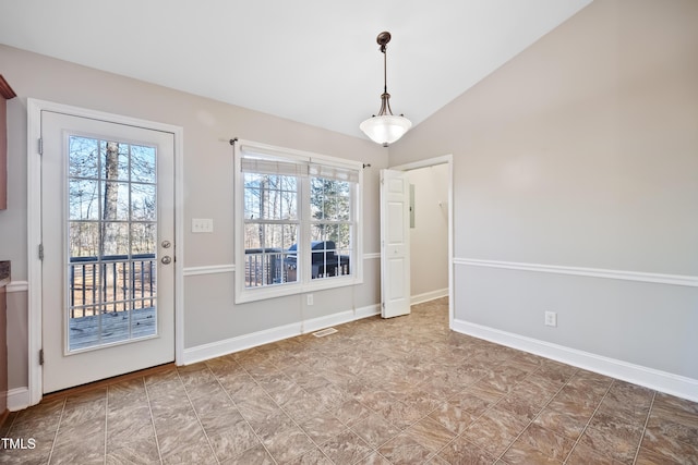 unfurnished dining area featuring a wealth of natural light and vaulted ceiling