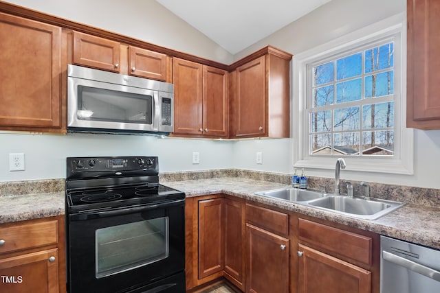 kitchen featuring appliances with stainless steel finishes, sink, and lofted ceiling