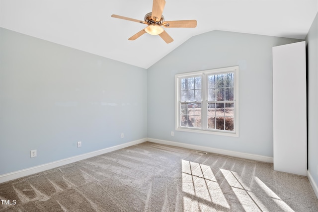 spare room featuring ceiling fan, vaulted ceiling, and carpet