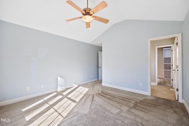 carpeted empty room featuring ceiling fan and lofted ceiling