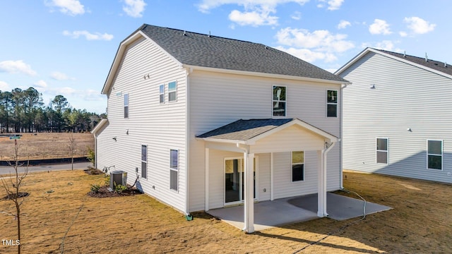 rear view of property with cooling unit, a yard, and a patio area