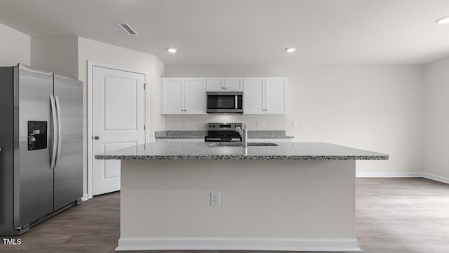 kitchen with sink, stainless steel appliances, light stone countertops, an island with sink, and white cabinets