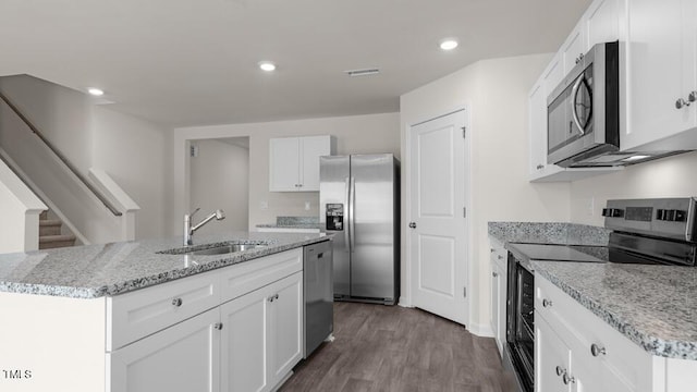 kitchen featuring white cabinetry, appliances with stainless steel finishes, sink, and a center island with sink