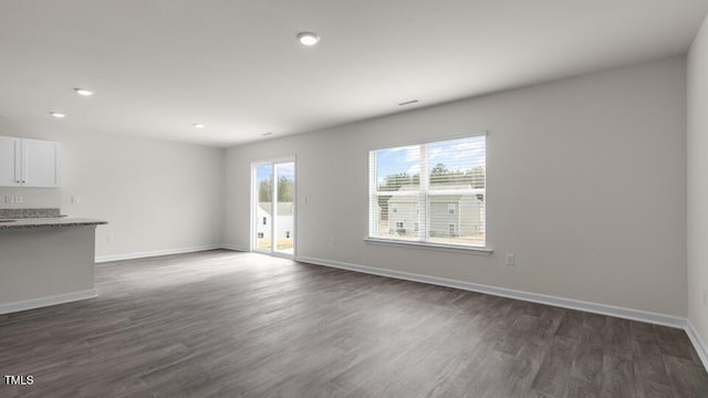 unfurnished living room with dark wood-type flooring