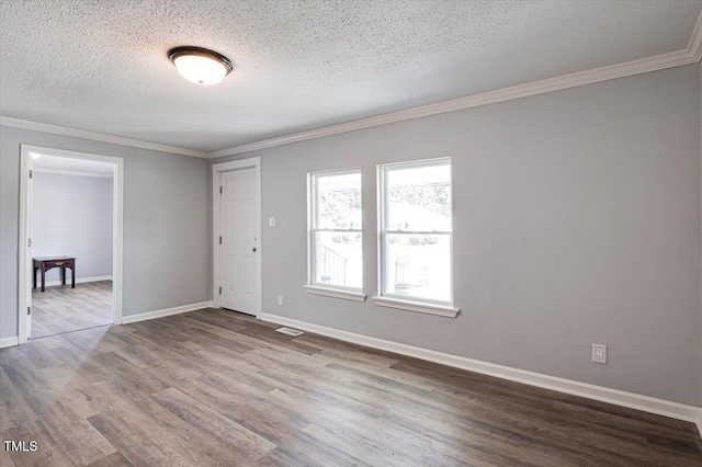 unfurnished room with hardwood / wood-style floors, crown molding, and a textured ceiling