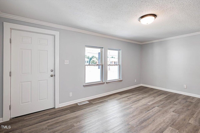 entryway with dark wood-type flooring, ornamental molding, and a textured ceiling