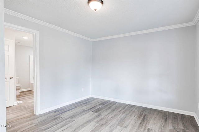 unfurnished room with ornamental molding, light hardwood / wood-style flooring, and a textured ceiling