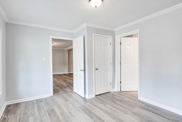 unfurnished room featuring ornamental molding, a textured ceiling, and light wood-type flooring