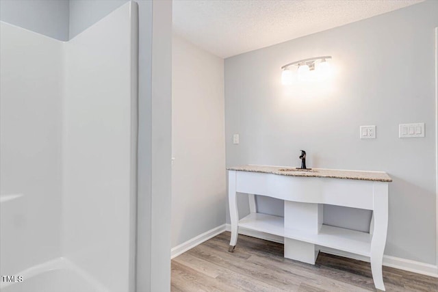 bathroom with hardwood / wood-style floors and a textured ceiling