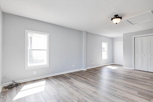 spare room featuring light hardwood / wood-style flooring and a textured ceiling