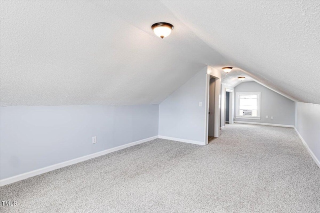 bonus room with lofted ceiling, light colored carpet, and a textured ceiling