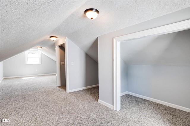 bonus room featuring carpet, lofted ceiling, and a textured ceiling