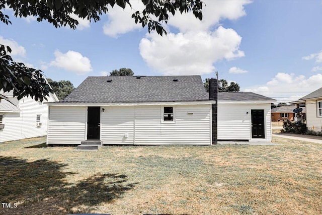 rear view of house featuring a yard