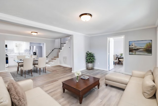 living room with crown molding and light hardwood / wood-style floors