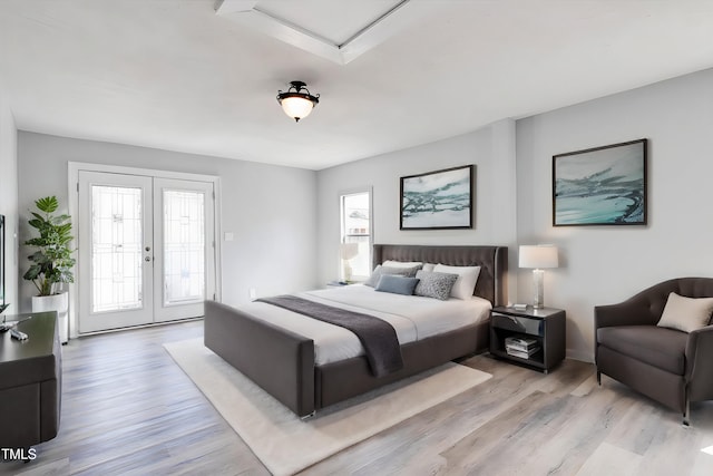 bedroom featuring access to outside, light wood-type flooring, and french doors