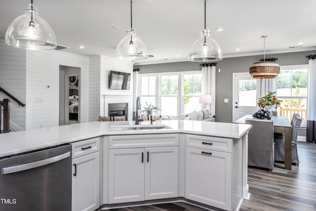 kitchen featuring pendant lighting, sink, white cabinetry, ornamental molding, and stainless steel dishwasher