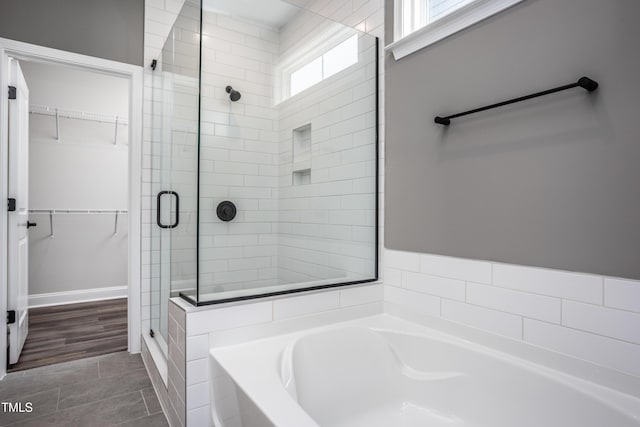 bathroom featuring shower with separate bathtub