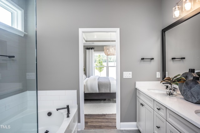 bathroom featuring vanity, a tub to relax in, and a tray ceiling