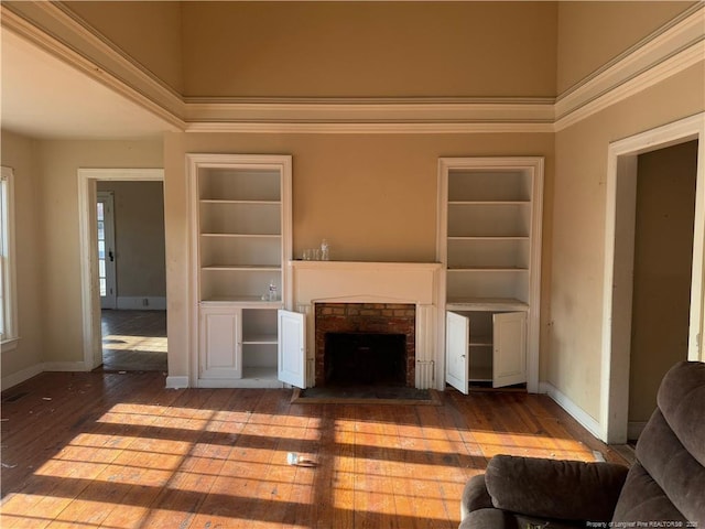 unfurnished living room featuring a fireplace, hardwood / wood-style floors, and built in features