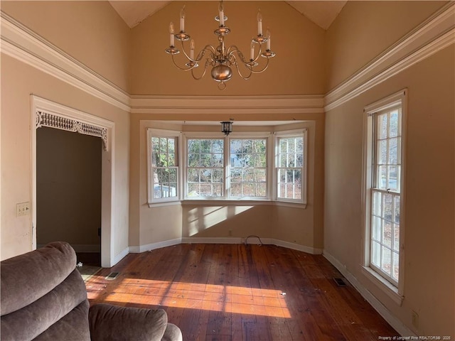 interior space with dark wood-type flooring, a chandelier, and high vaulted ceiling