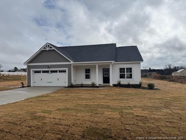 view of front of house featuring a garage, concrete driveway, and a front lawn