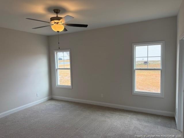 spare room with carpet floors, baseboards, and a ceiling fan