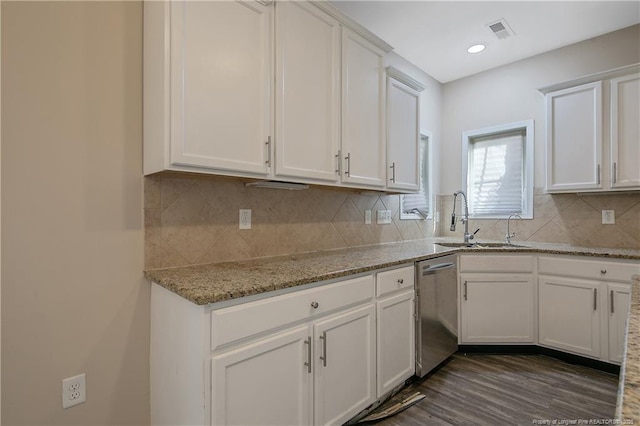 kitchen featuring sink, light stone counters, dishwasher, white cabinets, and backsplash