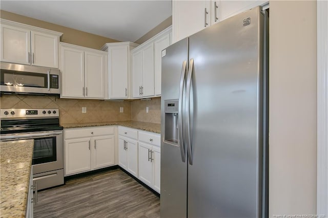 kitchen with light stone countertops, stainless steel appliances, and white cabinets